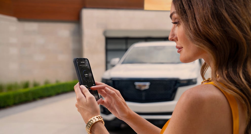 lady checking her mobile with a Cadillac vehicle background | Ed Martin Cadillac in ANDERSON IN